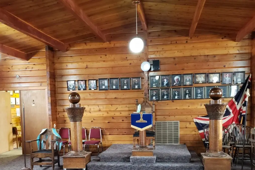 Lodge room at the Wetaskiwin Masonic hall, with the Master’s chair, pillars and past masters’ portraits.